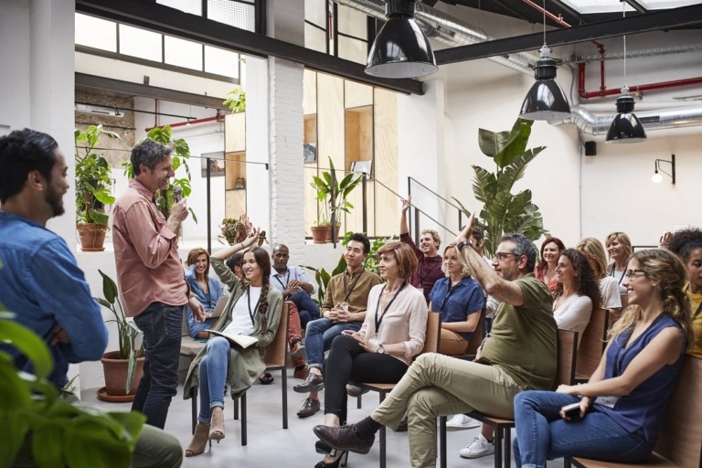 Business people with raised arms during seminar